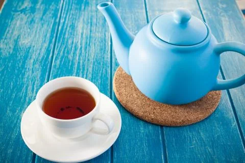 Cup of tea with the blue teapot on the table. Stock Photos