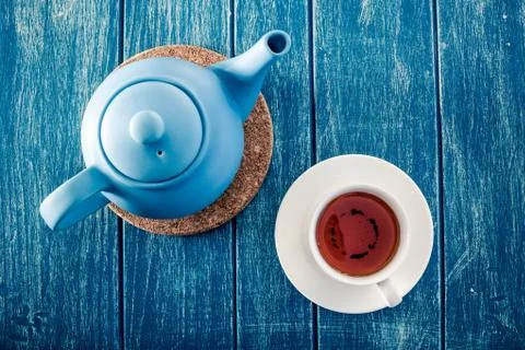Cup of tea with the blue teapot on the table. Stock Photos
