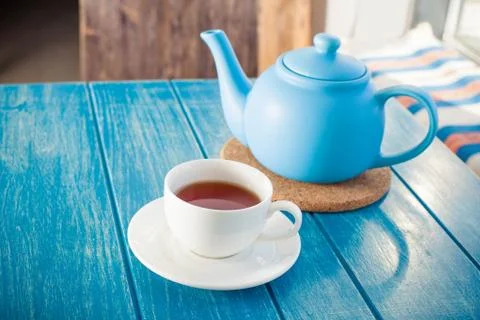 Cup of tea with the blue teapot on the table. Foto stock