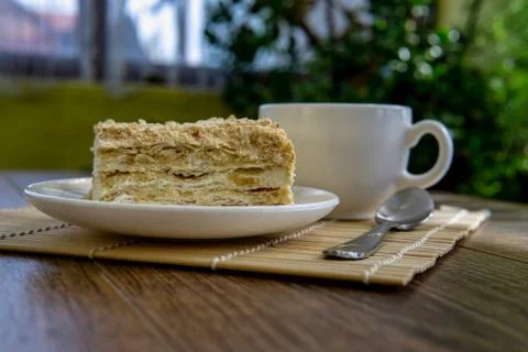 Cup of tea with cake on brown table background Foto stock