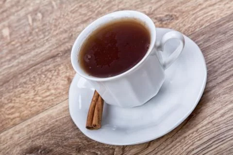 A cup of tea with cinnamon on a table Foto stock