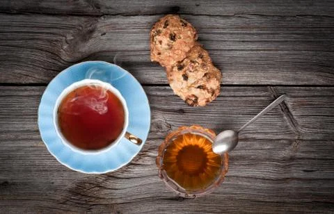 Cup of tea, cookies stack and honey on a wooden background 写真素材