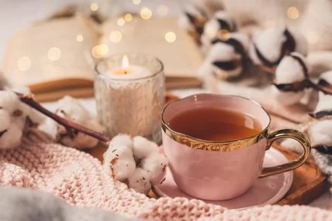 Cup of tea, cotton, cozy, book, candle. Cosy autumn winter concept. Stock Photos