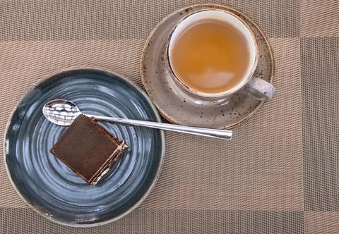 Cup of tea with delicious cake. Composition with tiramisu cakes and tea on ta Stock Photos