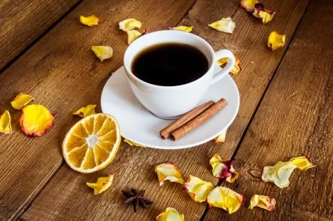 Cup of tea, dried orange, dried yellow rose petals on wooden background Stock Photos