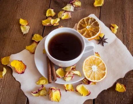 Cup of tea, dried oranges, dried rose petals on wooden background Stock Photos