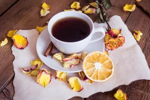 Cup of tea, dried oranges, dried rose petals on wooden background Stock Photos