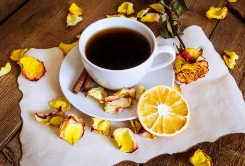 Cup of tea, dried oranges, dried rose petals on wooden background Stock Photos