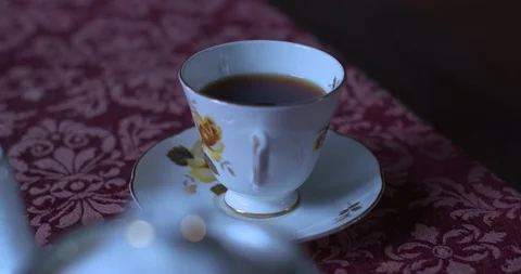 Cup of tea in flower pattern china cup old style table cloth Stock Footage 95007985