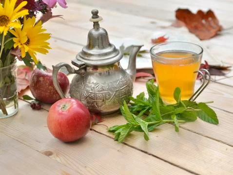Cup of tea with fresh mint leaf on a wooden table in autumnal decor Stock Photos
