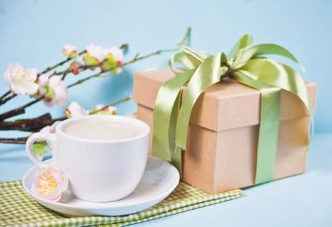 A cup of tea, gift box and cherry blooming with flowers sakura on the blue ba Photos