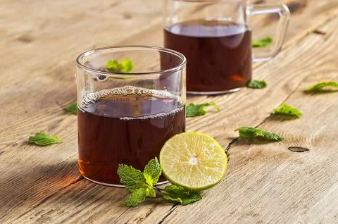 Cup of tea with ginger, lemon and mint on wooden table Stock Photos