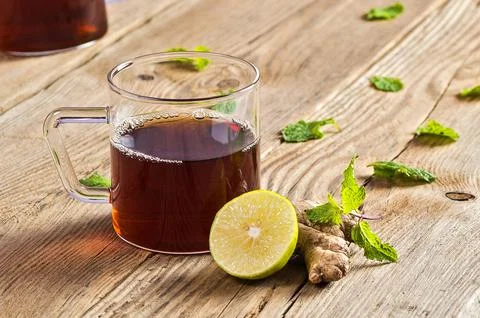 Cup of tea with ginger, lemon and mint on wooden table Stock Photos