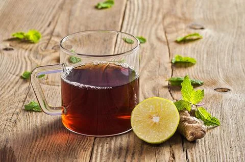 Cup of tea with ginger, lemon and mint on wooden table Stock Photos