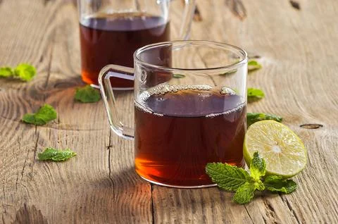 Cup of tea with ginger, lemon and mint on wooden table Stock Photos