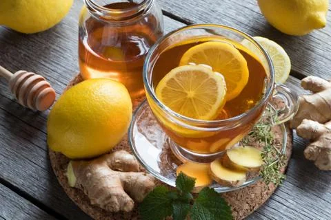 A cup of tea with ginger root, lemon, melissa and honey Stock Photos