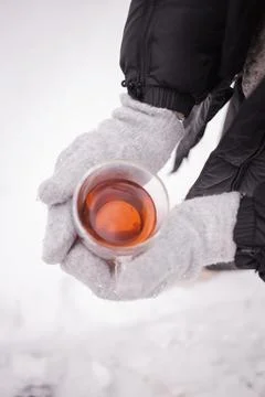 Cup of tea, gloved hands in winter Stock Photos