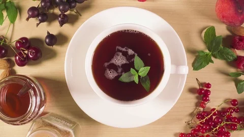 In a cup of tea, a hand puts a lemon Stock Footage 91890562