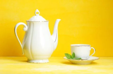 Cup of tea kettle on yellow Stock Photos