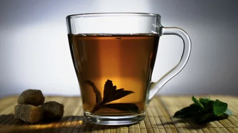 The cup of tea with leaves of mint turns around Stock Footage 73276721