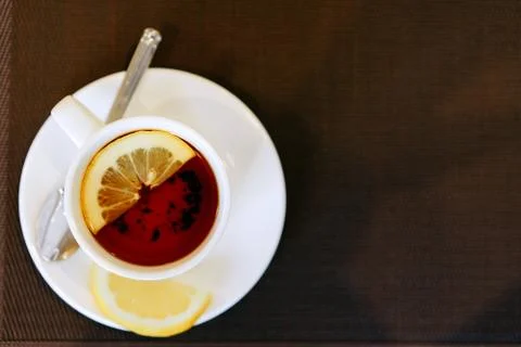 Cup of tea with lemon on a brown background Foto stock