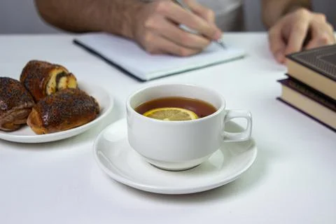 A cup of tea with lemon on a light background. Snack at work. A cup of tea at wo Stock Photos