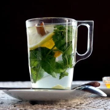 Cup of tea with lemon, mint, cinnamon and dessert Stock Photos