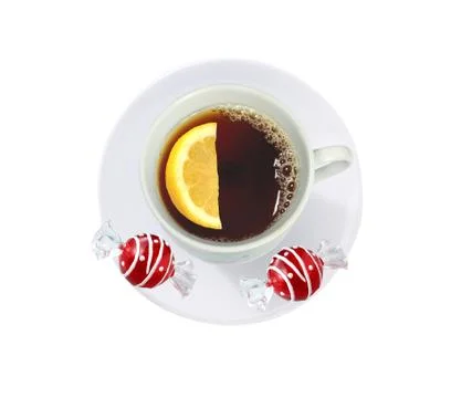 Cup of tea with lemon slice and candies isolated on white 库存照片