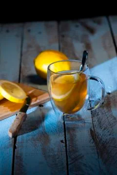 Cup of tea with a lemon slice surrounded by a cutting board with freshly cut Stock Photos