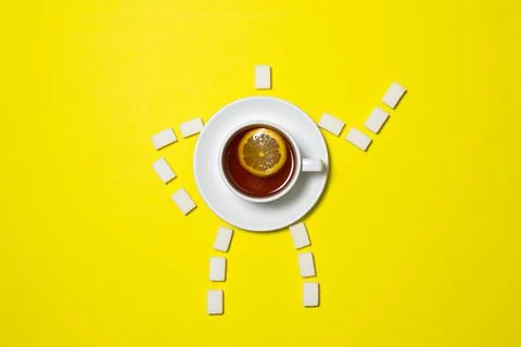 A cup of tea with lemon on a yellow background. Stock Photos