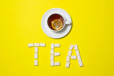 A cup of tea with lemon on a yellow background. Stock Photos