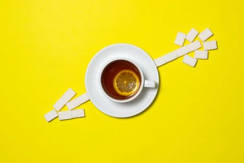 A cup of tea with lemon on a yellow background. Stock Photos