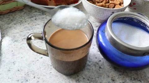 Cup of Tea with milk and sugar. Add one spoon of sugar in to the cup and mix it  Stock Footage 205875672