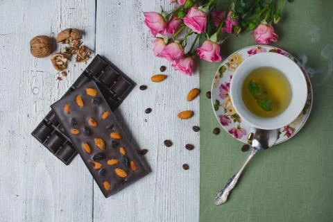 Cup of tea with mint and handmade chocolate bar on old table Stock Photos