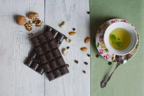 Cup of tea with on mint linen old table handmade chocolate bar filled with di Stock Photos