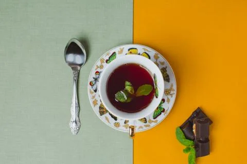 Cup tea with mint on linen table and Pieces of  chocolate bar filled Stock Photos