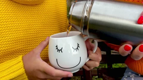 A cup of tea or coffee. Fragment of a woman's hand holding a metal thermos and Stock Footage 161540613