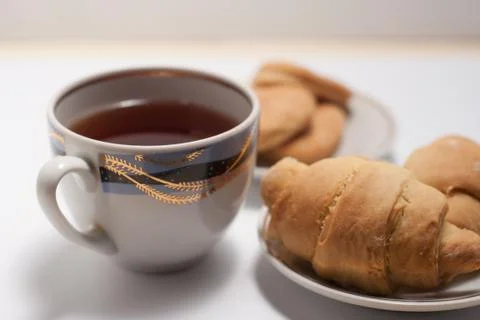 Cup of tea with pattern and fresh croissants Foto stock