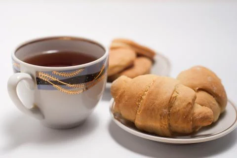 Cup of tea with pattern and fresh croissants Stock Photos