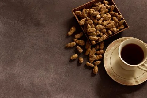 A cup of tea with peanuts on concrete background for any business such as log Stock Photos