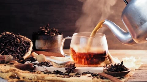 A cup of tea is placed on a wooden table with hot steam in slow motion Stock Footage 202159540
