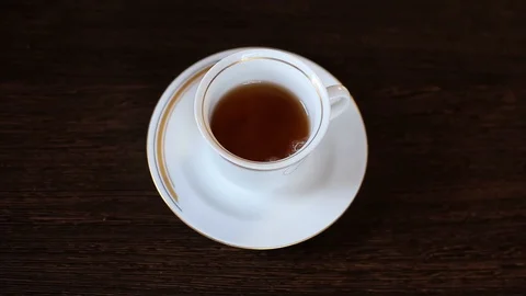 In a Cup of tea poured into milk Stock Footage 128429040