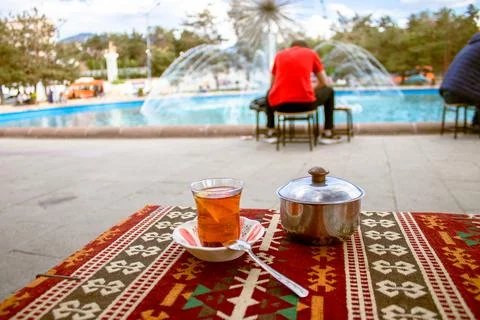 Cup of tea on a red-clad table and spending time in front of a pool Stock Photos