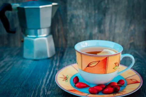 A cup of tea, rose hips and a kettle. Vitamins, disease prevention Stock Photos