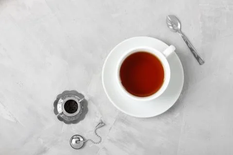 Cup of tea silver spoon little teapot on concrete background. Stock Photos