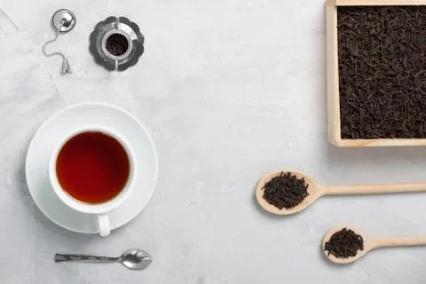 Cup of tea silver spoon little teapot on concrete background. Stock Photos