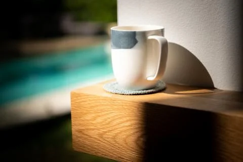 Cup of tea sitting on a solid wood American Oak mantle piece above fireplace Stock Photos