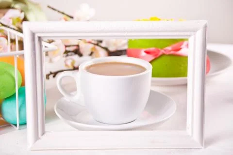 A cup of tea, small spring cake, flowers sakura, colorful eggs for Easter day Stock Photos