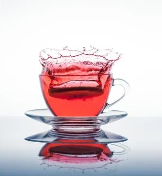 Cup of tea with splashes Stock Photos