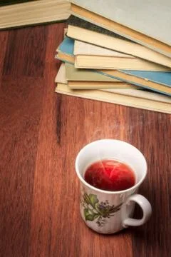 Cup of tea with stack of old books Stock Photos